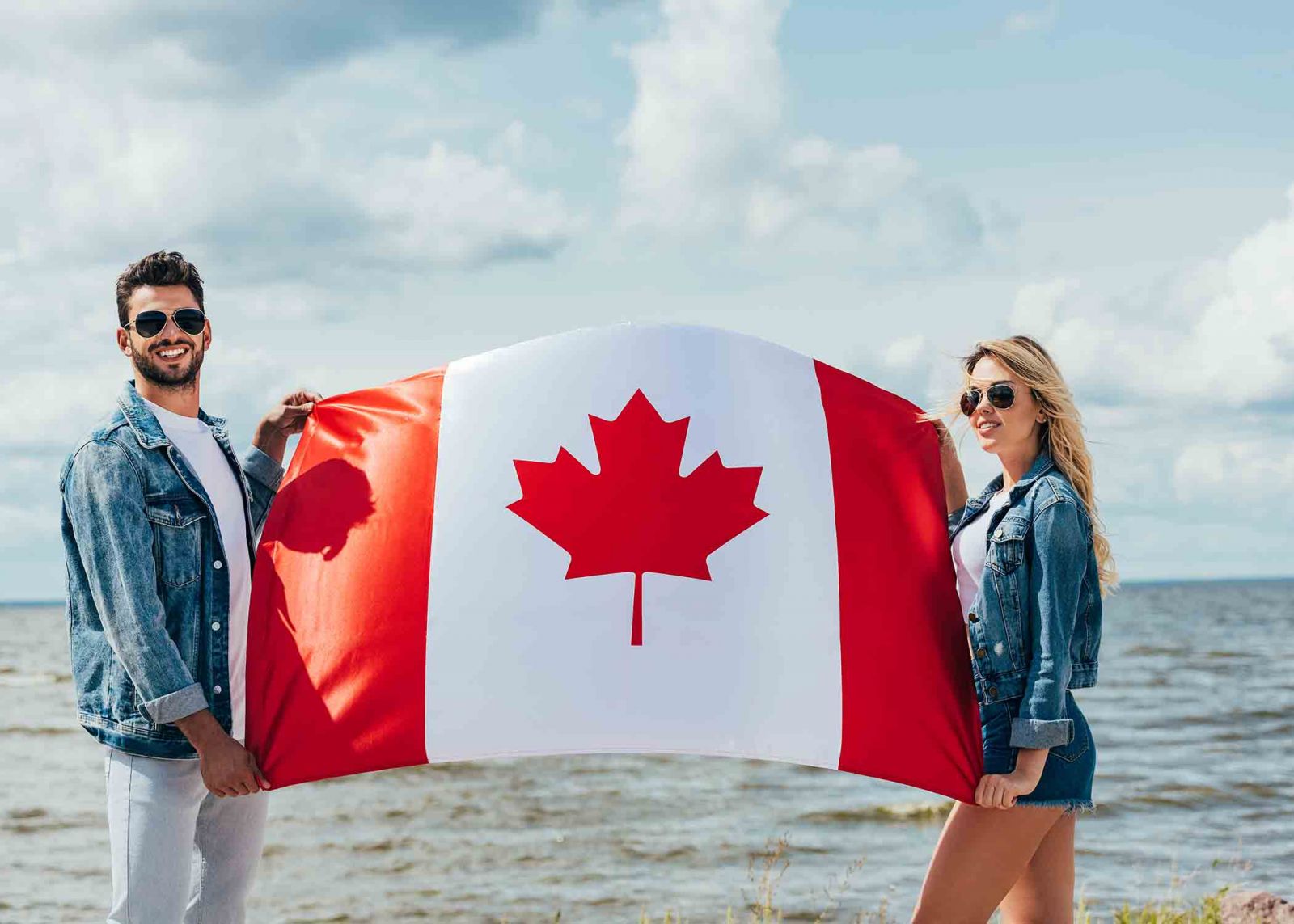 Couple holding a Canadian flag at the beach