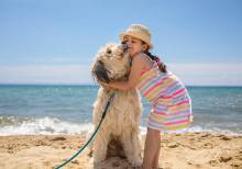 girl hugging her dog on the beach at the Grand Strand
